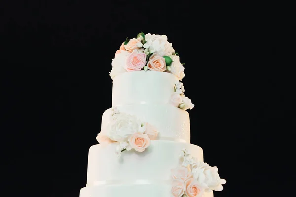 Luksusowy czteropoziomowy biały tort z kwiatami na czarnym tle, my — Zdjęcie stockowe