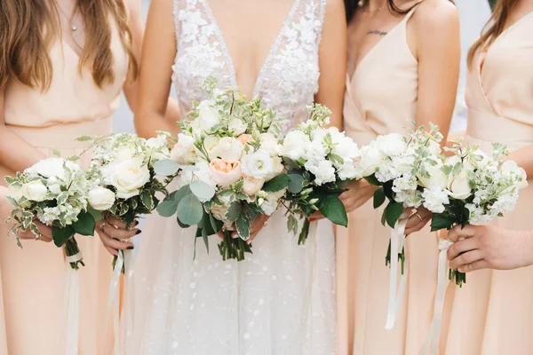 Härliga brudtärnor i ljusa klänningar med vackra blommor — Stockfoto