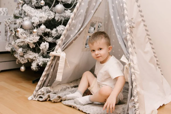 Ein kleiner süßer Junge sitzt im Kinderzimmer in einem zehn — Stockfoto