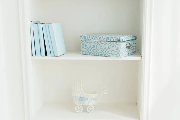 Βιβλιοθήκη με μπλε βιβλία, καροτσάκι μωρού. λευκό εσωτερικό. η δ — Φωτογραφία Αρχείου