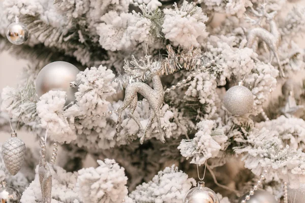 Árvore de Natal branca coberta de neve com brinquedos de prata e veados, sel — Fotografia de Stock