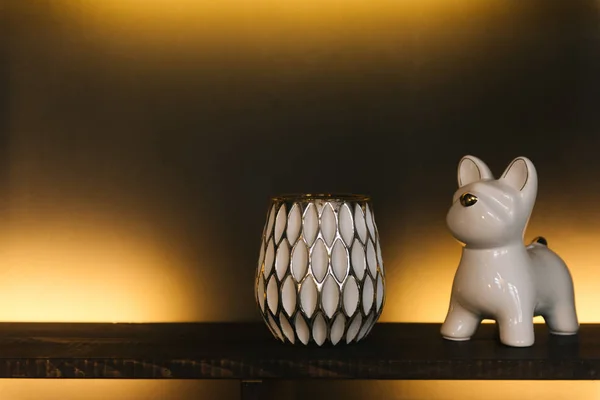 illuminated shelf with candle and dog sculpture