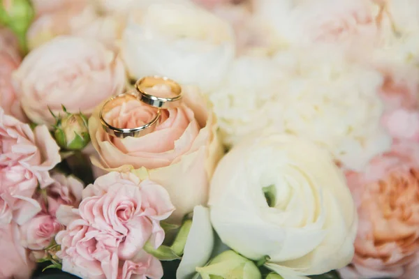 Los anillos de boda sobre el fondo de las flores de la boda tierna bou — Foto de Stock
