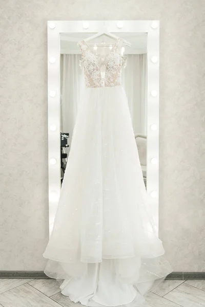 Brudklänning hängande på spegeln, brudens morgon — Stockfoto