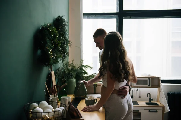 美丽的年轻 时尚的怀孕女孩和丈夫在厨房里用棉花糖煮可可 — 图库照片