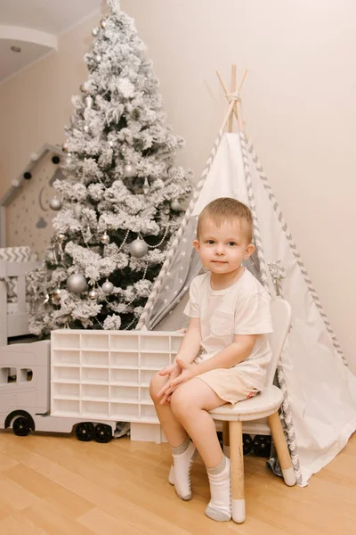 Kleiner süßer Junge sitzt im Kinderzimmer in einem Zelt — Stockfoto