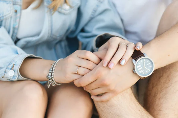 Loving couple holding hands sitting on the sand close up of hand — Stock Photo, Image