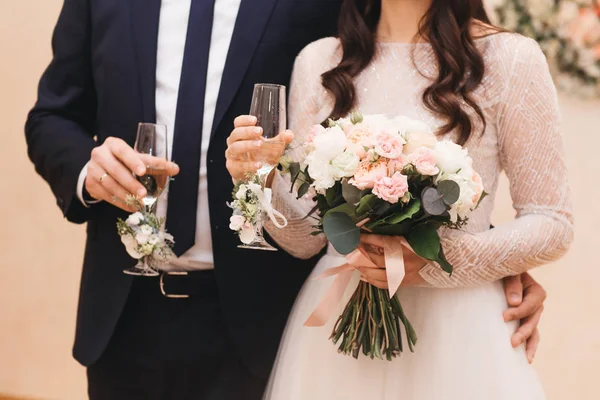 Novia y novio sosteniendo gafas de boda bellamente decoradas wi — Foto de Stock