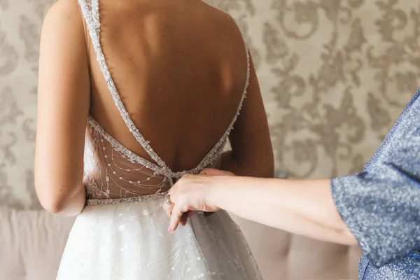 Morning bride. Bridesmaid helping the bride lacing up her dress. — Stock Photo, Image