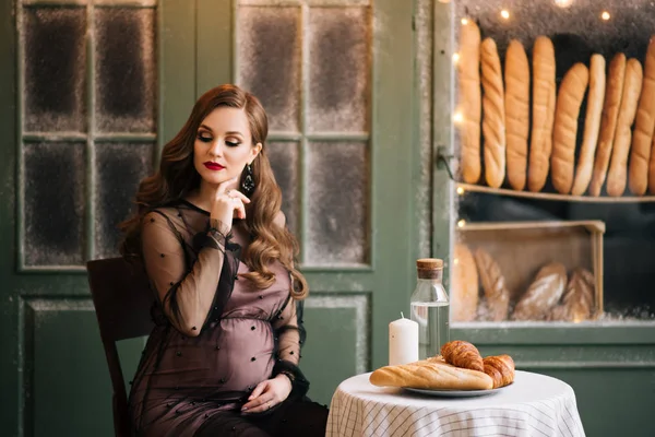 美しい若い スタイリッシュな妊娠中の女の子 黒いドレスで フランスのパン屋の内部 — ストック写真