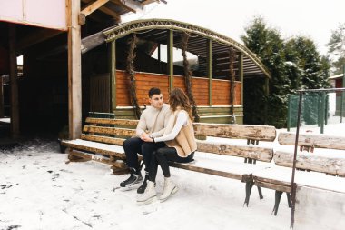 Buzlu kış aşkı hikayesi. Güzel genç adam ve kız buz üstünde kayıyorlar.