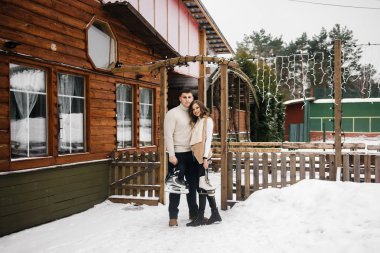 Buzlu kış aşkı hikayesi. Şık bir adam ve kız ellerinde patenle buz patenine gidiyorlar.