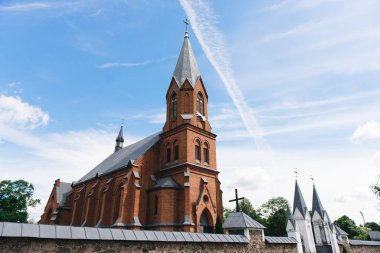 Mavi bulutlu gökyüzünde eski katolik katedral binası