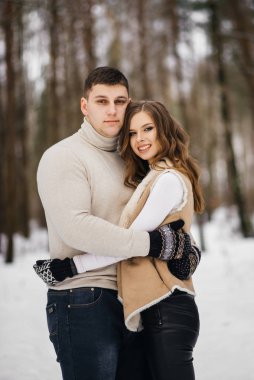 Buzlu kış aşkı hikayesi. Karlı ormanda yürüyen şık bir adam ve kız. Aşk.