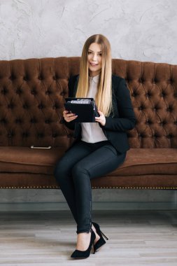 İç stüdyodaki genç ve güzel bir iş kadınının portresi. Elinde defter olan bir kız.