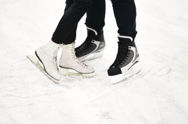 Winter love story on ice. Skating lovers a boy and a girl closeup clipart