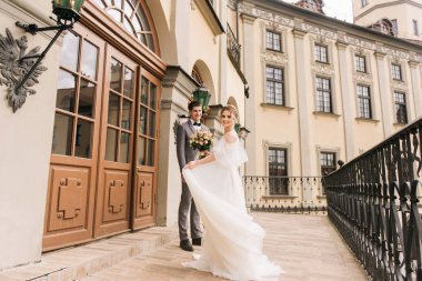 Eski bir binanın arka planında ve kaldırım taşlarında, Avrupa düğününde birbirine aşık güzel, zarif bir çift.