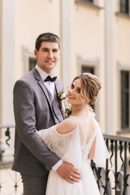 Eski bir binanın arka planında ve kaldırım taşlarında, Avrupa düğününde birbirine aşık güzel, zarif bir çift.