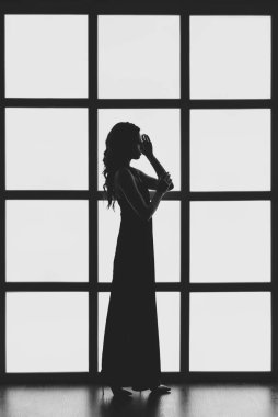 Tavan arasında arka lambası olan bir kızın silueti.