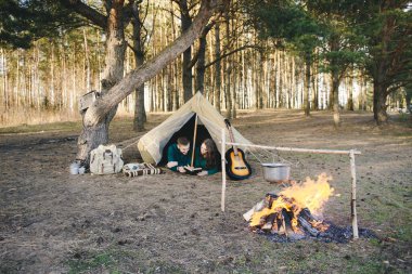 Aşık genç çift ormandaki eski bir çadırda yatan turistlere kamp kuruyor.