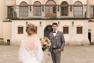 Eski bir binanın arka planında ve kaldırım taşlarında, Avrupa düğününde birbirine aşık güzel, zarif bir çift.