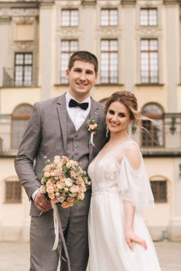 Eski bir binanın arka planında ve kaldırım taşlarında, Avrupa düğününde birbirine aşık güzel, zarif bir çift.