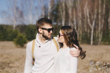 Mutlu kız ve erkek turist çantalı ve gitarlı doğa yürüyüşü, seyahat aşk hikayesi konsepti, seçici odaklanma