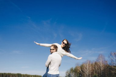 Mutlu kız ve erkek gökyüzüne doğru koşuyor ve sarılıyorlar, seyahat aşk hikayesi konsepti, seçici odaklanma