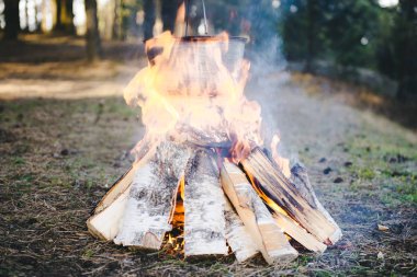 Saha koşullarında yemek pişirmek, piknikte kamp ateşinde demlik pişirmek. Filtrelenmiş resim: çapraz işlenmiş vintage etkisi. 