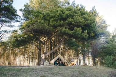 Aşık genç çift ormandaki eski bir çadırda yatan turistlere kamp kuruyor.