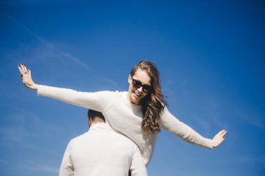 Mutlu kız ve erkek gökyüzüne doğru koşuyor ve sarılıyorlar, seyahat aşk hikayesi konsepti, seçici odaklanma