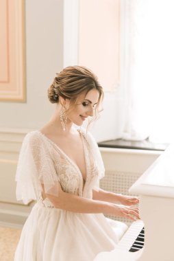 Lüks bir iç mekanda piyanonun yanında güzel bir gelinin portresi.