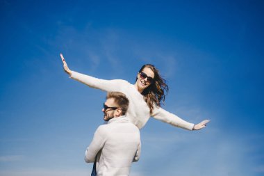 Mutlu kız ve erkek gökyüzüne doğru koşuyor ve sarılıyorlar, seyahat aşk hikayesi konsepti, seçici odaklanma