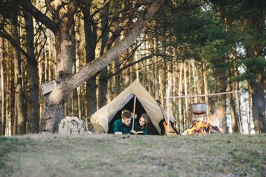 Aşık genç çift ormandaki eski bir çadırda yatan turistlere kamp kuruyor.