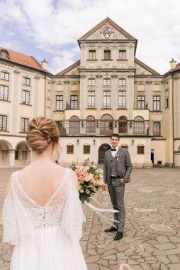 Eski bir binanın arka planında ve kaldırım taşlarında, Avrupa düğününde birbirine aşık güzel, zarif bir çift.