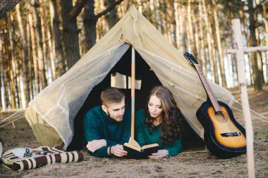 Aşık genç çift ormandaki eski bir çadırda yatan turistlere kamp kuruyor.
