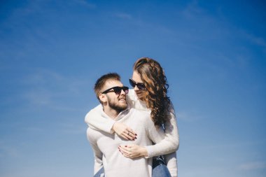 Mutlu kız ve erkek gökyüzüne doğru koşuyor ve sarılıyorlar, seyahat aşk hikayesi konsepti, seçici odaklanma