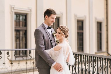 Eski bir binanın arka planında ve kaldırım taşlarında, Avrupa düğününde birbirine aşık güzel, zarif bir çift.