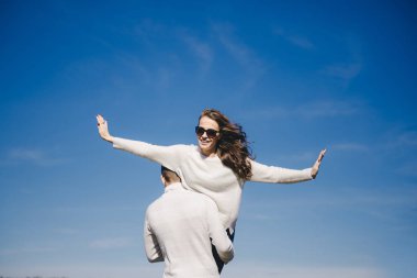 Mutlu kız ve erkek gökyüzüne doğru koşuyor ve sarılıyorlar, seyahat aşk hikayesi konsepti, seçici odaklanma