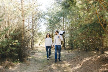 Mutlu kız ve erkek turist çantalı ve gitarlı doğa yürüyüşü, seyahat aşk hikayesi konsepti, seçici odaklanma