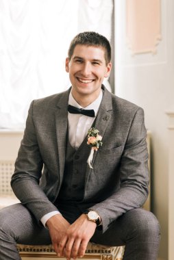 Genç bir adamın mutlu damat portresi. Damat düğün günü için odada hazırlanıyor..