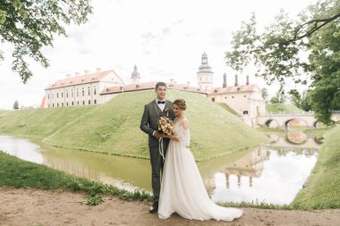 Avrupa 'da eski bir şatonun arka planında birbirine aşık güzel, zarif bir çift.