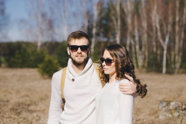 Mutlu kız ve erkek turist çantalı ve gitarlı doğa yürüyüşü, seyahat aşk hikayesi konsepti, seçici odaklanma