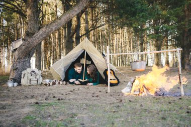 Aşık genç çift ormandaki eski bir çadırda yatan turistlere kamp kuruyor.
