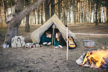 Aşık genç çift ormandaki eski bir çadırda yatan turistlere kamp kuruyor.