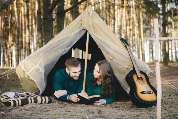 Aşık genç çift ormandaki eski bir çadırda yatan turistlere kamp kuruyor.