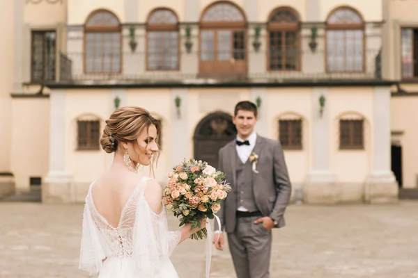 古い建物や舗装石 ヨーロッパの結婚式の背景に恋に新婚旅行の美しいエレガントなカップル — ストック写真