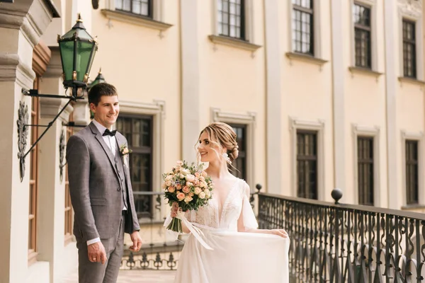 古い建物や舗装石 ヨーロッパの結婚式の背景に恋に新婚旅行の美しいエレガントなカップル — ストック写真