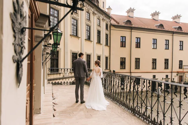 Eski bir binanın arka planında ve kaldırım taşlarında, Avrupa düğününde birbirine aşık güzel, zarif bir çift.