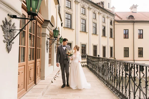 Eski bir binanın arka planında ve kaldırım taşlarında, Avrupa düğününde birbirine aşık güzel, zarif bir çift.